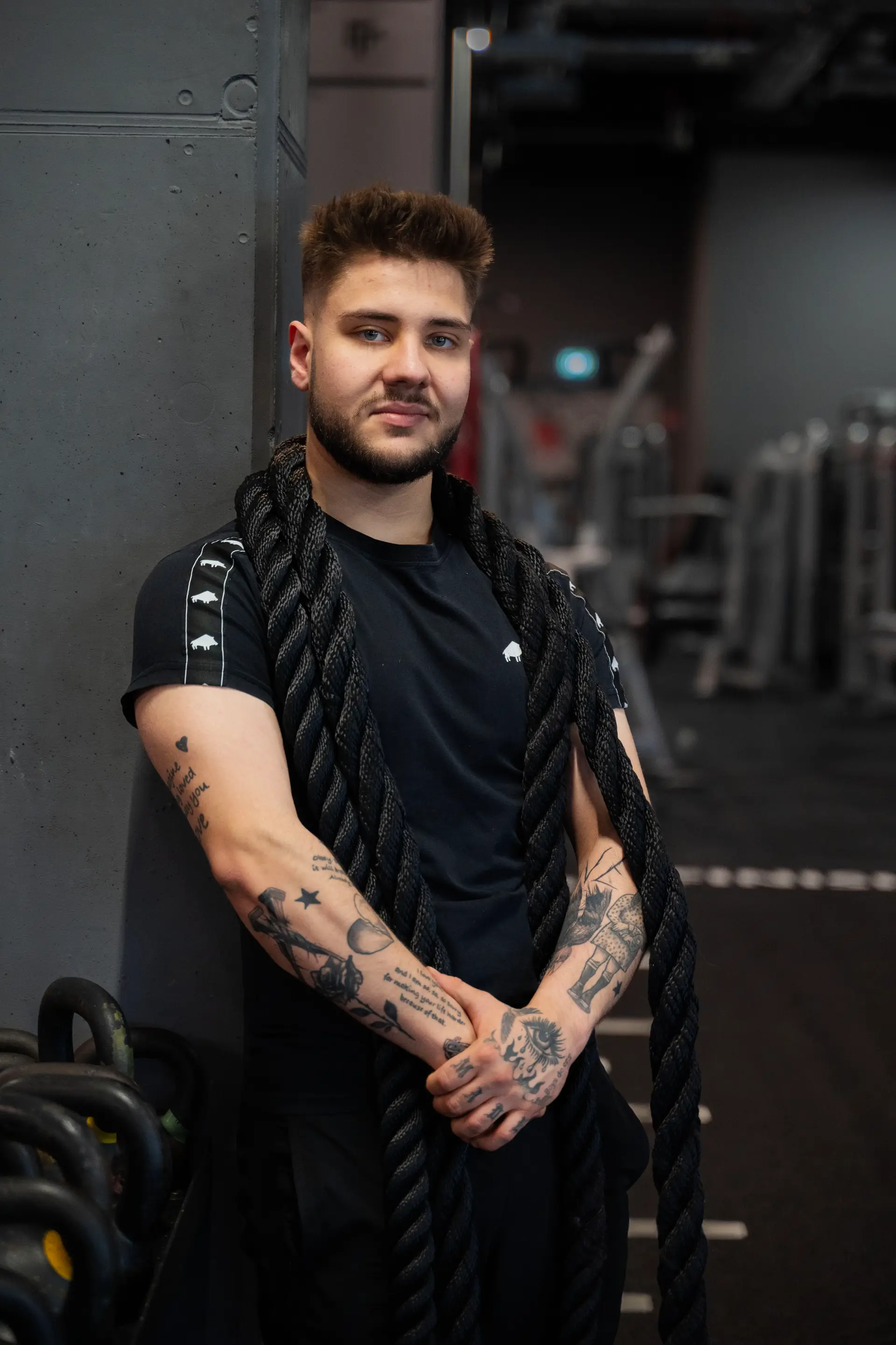 Jakub Gibas z liną treningową na siłowni